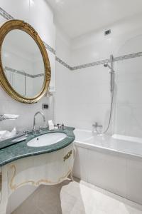 La salle de bains est pourvue d'un lavabo, d'un miroir et d'une baignoire. dans l'établissement Hotel Ca' dei Conti, à Venise