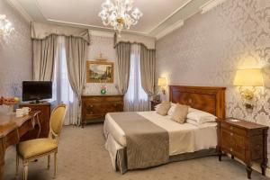 - une chambre avec un lit, un bureau et une télévision dans l'établissement Hotel Ca' dei Conti, à Venise