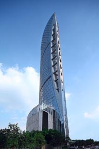 un edificio di alto vetro con un cielo blu sullo sfondo di Minyoun Chengdu Dongda Hotel a Chengdu