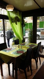 uma mesa num restaurante com uma toalha de mesa verde em Hôtel du Roc em Castellane