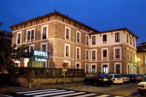 ein großes Backsteingebäude mit davor geparkt in der Unterkunft Hotel Luzon in San Vicente de la Barquera