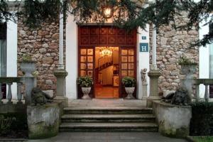 eine Tür zu einem Gebäude, zu dem eine Treppe führt in der Unterkunft Hotel Luzon in San Vicente de la Barquera