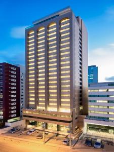 un edificio alto con luces encendidas en una ciudad en Sotero Hotel by Castelo Itaipava, en Salvador