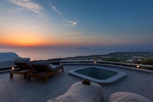 una piscina con vista sull'oceano al tramonto di Villa Vinea Santorini a Imerovigli