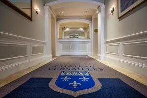 un couloir avec un tapis bleu portant le logo des chefs dans l'établissement Chateau Versailles, à Montréal