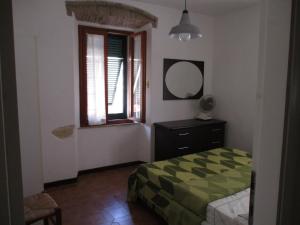 1 dormitorio con cama, espejo y ventana en Casa Porto Azzurro, en Porto Azzurro