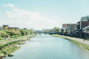 a river in a city with a bridge in the background at Len Kyoto Kawaramachi in Kyoto