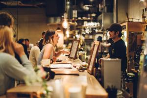 a group of people sitting at a counter in a restaurant at Len Kyoto Kawaramachi in Kyoto