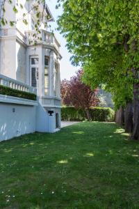 una casa bianca con un cortile con erba e alberi di Villa 81 a Deauville