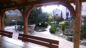 un jardin avec une pergola en bois et un banc dans l'établissement Hotel Kameralny, à Kielce