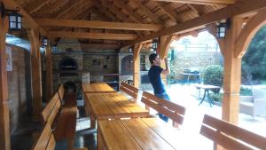 un homme debout dans un pavillon avec des bancs en bois dans l'établissement Hotel Kameralny, à Kielce