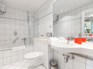 uma casa de banho branca com um WC e um lavatório em DORMERO Hotel Dresden Airport em Dresden