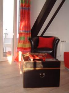 a living room with a chair and a trunk at Appartement Kirschgarten Mainz Rochusstraße in Mainz