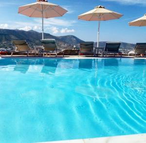 a large swimming pool with chairs and umbrellas at Krotiri Bay -adults only in Parikia