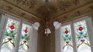 a ceiling with stained glass windows in a room at Hotel El Xalet in Sitges