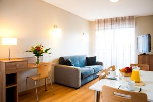 een woonkamer met een bank en een tafel bij Lagrange Aparthotel Toulouse Saint-Michel in Toulouse