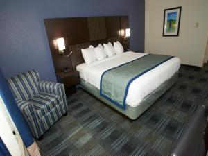 a hotel room with a bed and a chair at Falmouth Inn in Falmouth