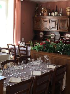 una sala da pranzo con tavolo e bicchieri da vino di Hôtel de la Gare a Yvonand