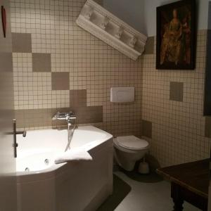 ein Badezimmer mit einer Badewanne, einem WC und einem Waschbecken in der Unterkunft Chambres touristiques La Cour Des Hôtes in Obernai