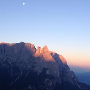 Una montaña con la luna en el cielo en Mahlknechthuette Seiseralm, en Alpe di Siusi