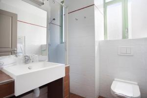 bagno bianco con lavandino e servizi igienici di Odalys City Nice Le Palais Rossini a Nizza