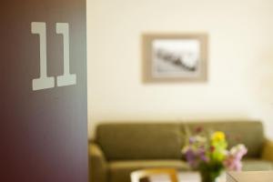 uma sala de estar com um sofá e uma mesa com flores em Familienhotel Weimar mit Ferienwohnungen em Veimar