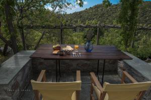 uma mesa de madeira com comida e bebidas num pátio em Urania Traditional Stone House em Pinakátai