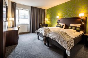 a hotel room with a large bed and a desk at Thon Partner Hotel Victoria Hamar in Hamar