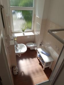 baño con aseo y lavabo y ventana en Pension Fischerjung, en Rostock