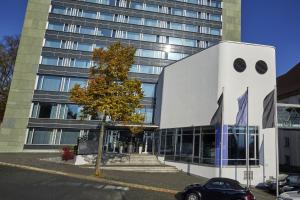 H4 Hotel Kassel في كاسيل: سيارة متوقفة أمام مبنى