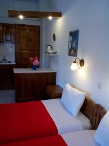 a bedroom with two beds and a kitchen with a counter at Sofia's Garden Studios in Skopelos Town