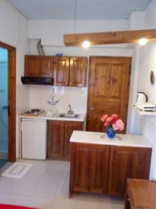 a kitchen with wooden cabinets and a sink at Sofia's Garden Studios in Skopelos Town