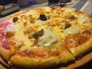 eine Pizza auf einer Holzplatte in der Unterkunft Casablu Hotel in Nouakchott