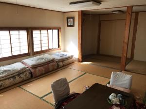 een kamer met twee bedden en een tafel erin bij Niko Ryokan in Aizuwakamatsu