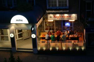 un groupe de personnes assises dans un restaurant la nuit dans l'établissement Hotel Willinger Mitte, à Willingen