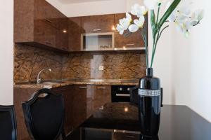 um vaso com flores brancas sobre uma mesa na cozinha em Boutique Apart Hotel Versis em Sunny Beach