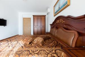 um quarto com uma cama grande e uma cabeceira em madeira em Boutique Apart Hotel Versis em Sunny Beach