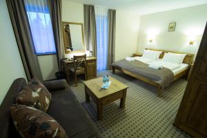 een hotelkamer met een bed en een bank bij Hotel Biathlon Sport & Spa in Szklarska Poręba