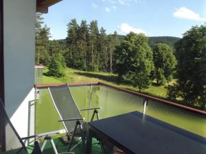 einen Tisch und Stühle auf einem Balkon mit Aussicht in der Unterkunft Apartmán Lipno A12 in Lipno nad Vltavou