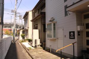 広島市にあるHiroshima Guesthouse HARUの白い建物の横の路地