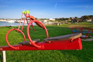 einen roten Spielplatz mit einer Bank und einem Skateboard in der Unterkunft Holiday home M1 & M2 in Pula