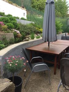 an umbrella sitting next to a wooden table and chairs at Apartman Za Potokem in Luhačovice