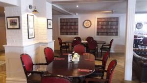 een eetkamer met tafels en stoelen en een klok bij Glendine Inn in Kilkenny