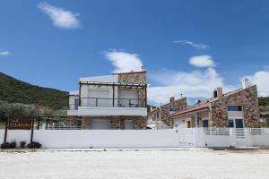 einen weißen Zaun vor einem Haus in der Unterkunft Petritis Villas in Nea Iraklitsa