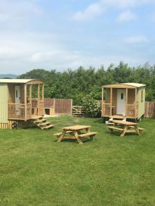 um grupo de cabanas e mesas de piquenique na relva em Orme View Lodges em Bangor