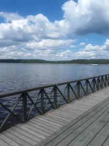 een houten brug over een grote hoeveelheid water bij Pokoje i domki nad Kanałem Bystrym in Augustów