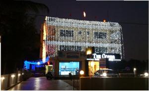 a building with lights on the side of it at night at Ocean Crest Hotel in Colva