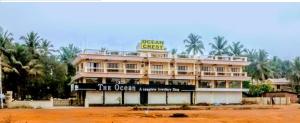 a building with a sign on top of it at Ocean Crest Hotel in Colva