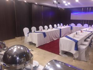 einen Konferenzraum mit weißen Tischen und weißen Stühlen in der Unterkunft Casablu Hotel in Nouakchott