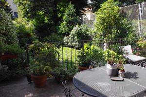 a patio with a table and chairs and plants at Teodora B&B in Milan